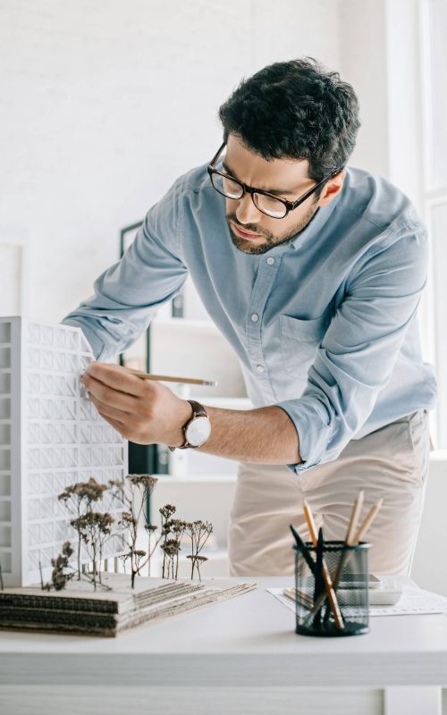 handsome-architect-working-with-architecture-model-on-table-in-office.jpg